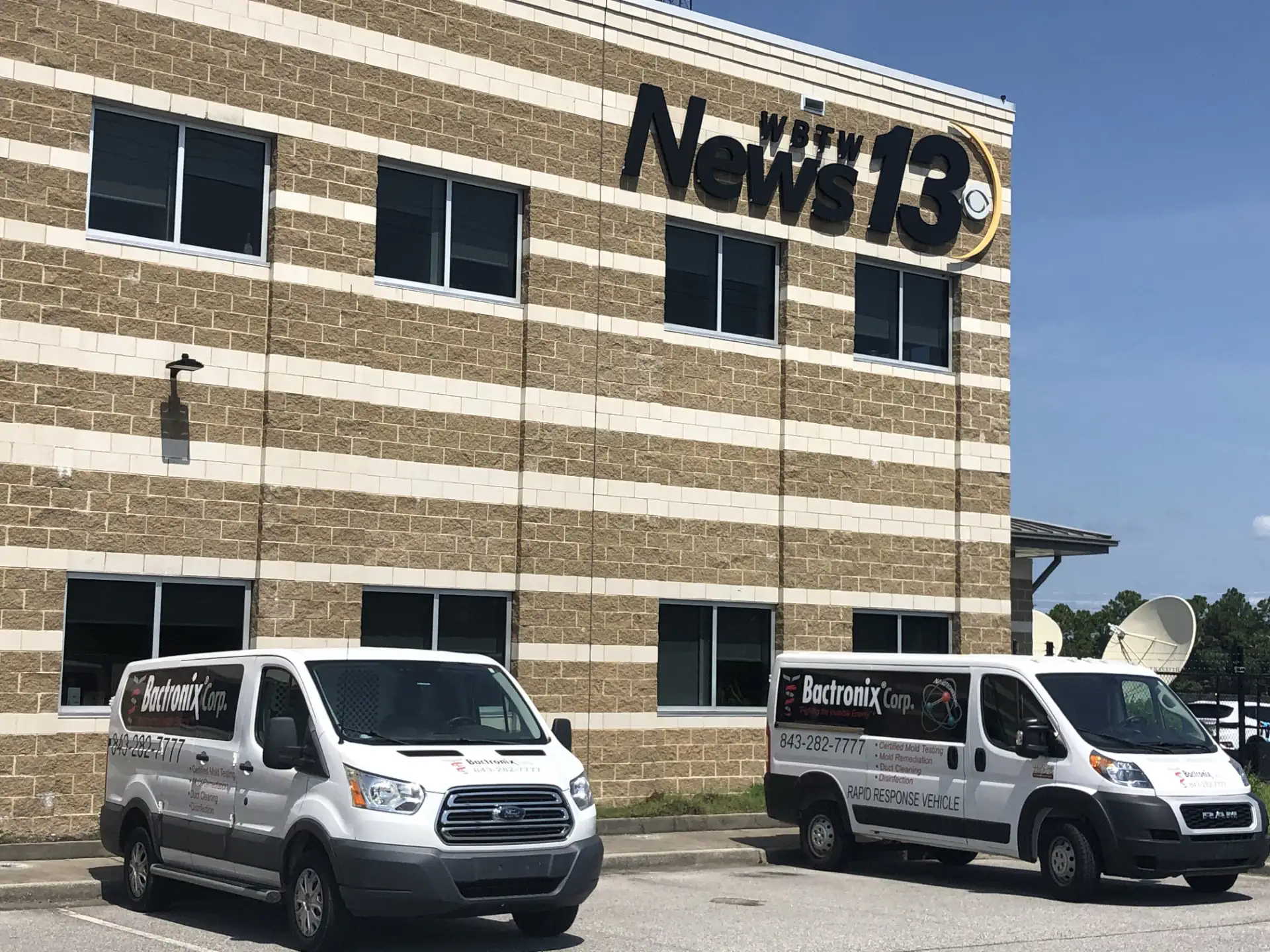 Two Bactronix service vans parked outside a commercial building on a job